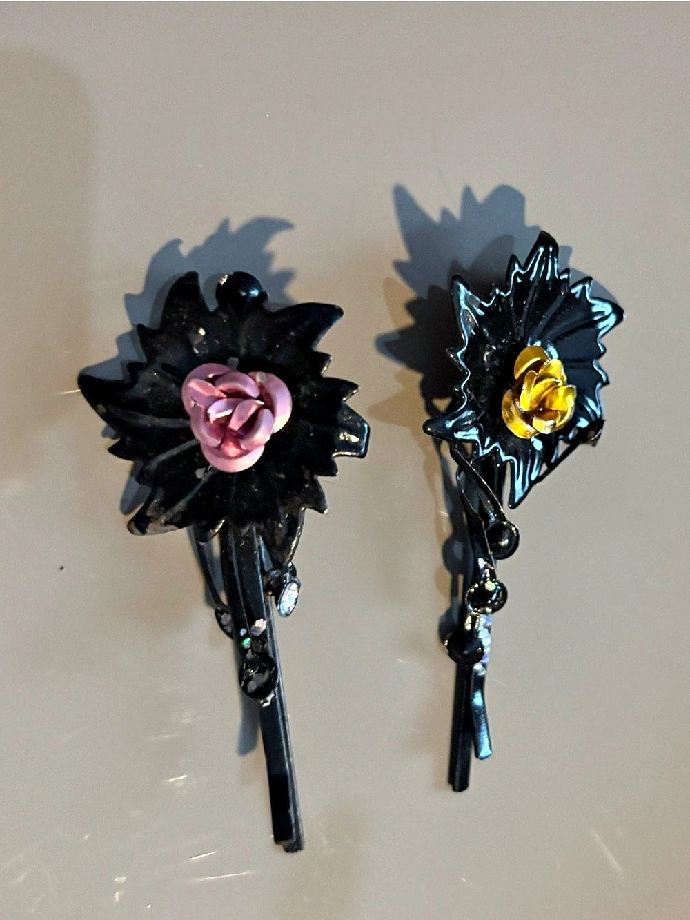 Two black hair barrettes, one yellow one and pink one